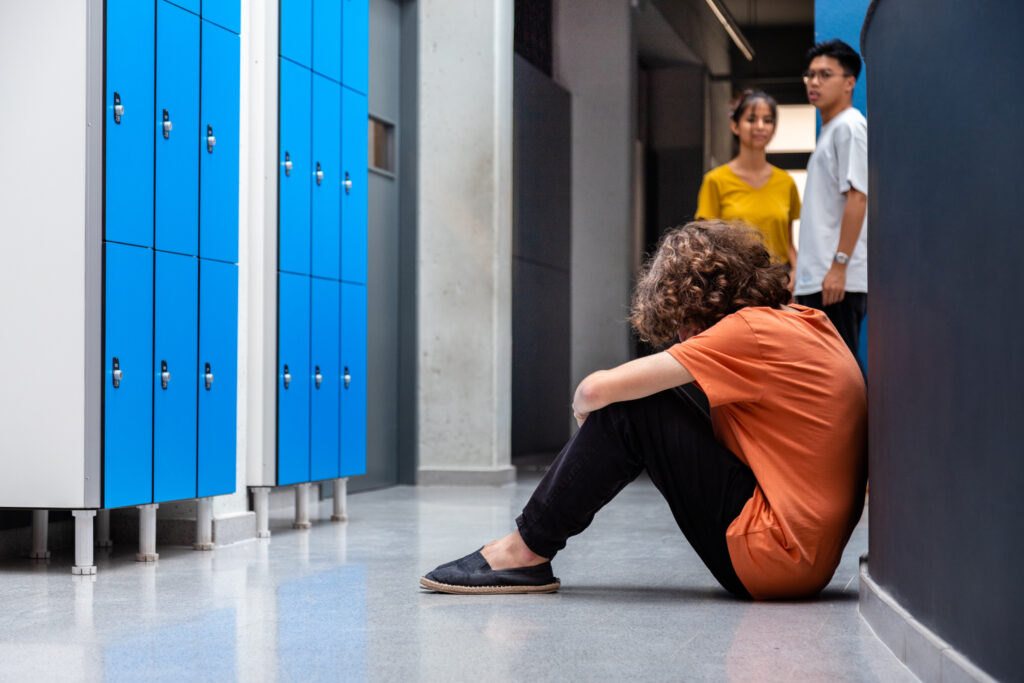 sad teen boy sitting on floor in high school corri 2023 11 27 05 27 06 utc scaled